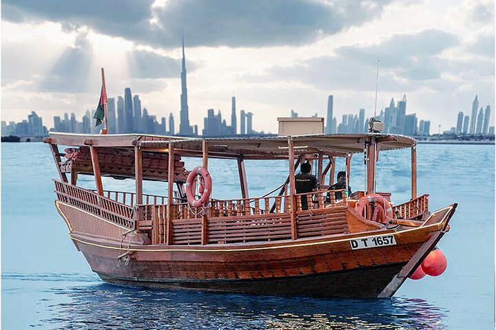 Drift along Dubai Canal in a traditional Abra soaking in serene views of the Burj Khalifa's sunset with comfortable seating and insightful commentary highlighting the city's beauty.